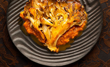 Seared hen of the woods recipe on a pretty black plate