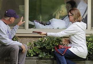 Image result for image of visiting nursing home resident looking through glass