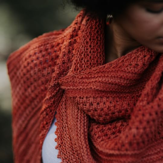 Close-up of woman wearing a coral textured hand knit shawl.