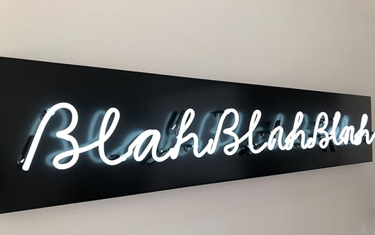 A neon sign with white letters against a black background reads 