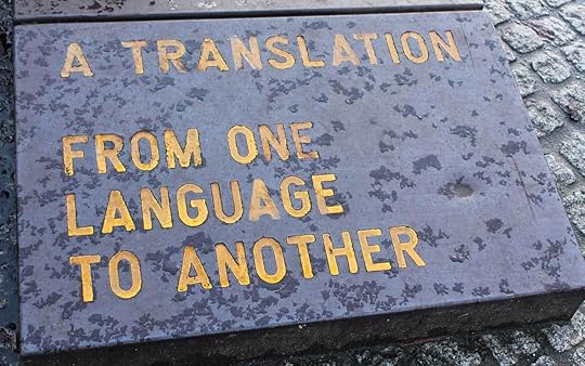 A gray stone laid in the ground with yellow text that reads, 