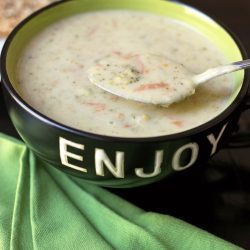 ENJOY bowl full of broccoli soup next to green napkin