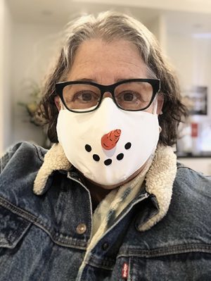 Amy wearing a mask that looks like a snowman's face