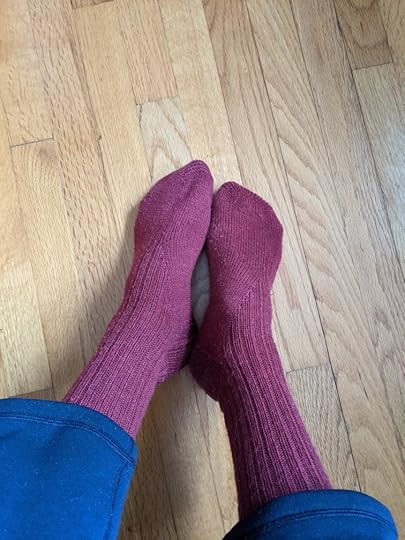 A photo of wool socks that have been dyed a purple-red