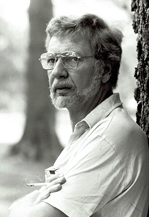 Black and white photograph of Walter Tevis holding a lit cigarette.