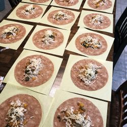 burritos assembled in an array on kitchen table