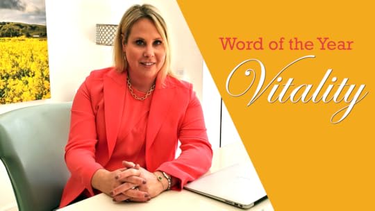 A blonde woman in a coral-colored shirt and blazer looks at the camera. A white yellow triangle on the side of the image has the words