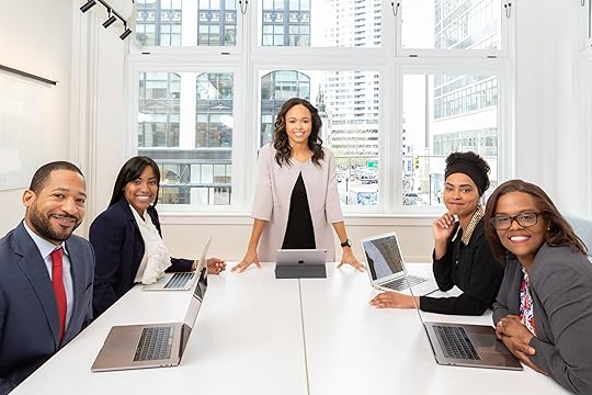 People at a meeting, smilling for the camera ( Photo by Rebrand Cities from Pexels)