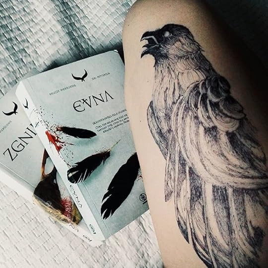 Closeup of a forearm with a raven tattoo, lying beside the Polish editions of The Rot and The Might