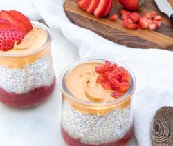 Two Jars of PB&J Chia Parfait with Sliced Strawberries on a White Towel