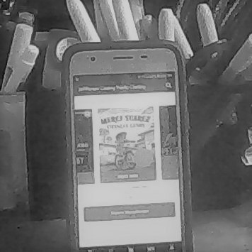 Merci Suárez Changes Gears--cover on a cell phone propped against a pen holder.On the cover, a girl rides a bicycle.