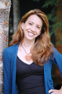 author headshot of strawberry blonde white woman with black tank, blue cardigan and statement necklace