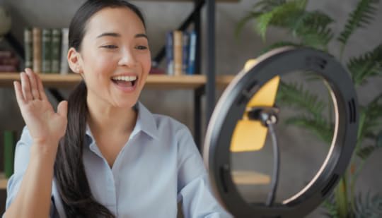 Enthusiastic presentation skills workshop participant presenting to device mounted in a ring light