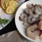 fish and shrimp on plate with lemon