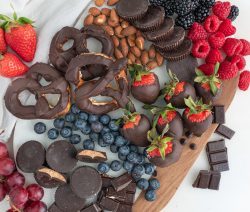 Board with chocolate pretzels, peanut butter buts and a variety of berries
