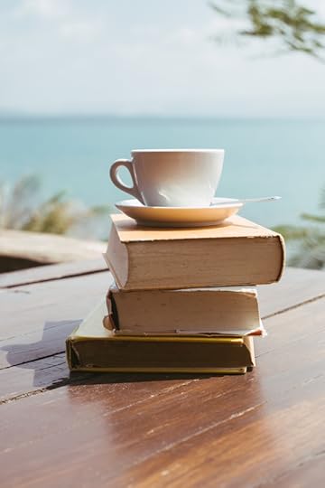 coffee cup resting on a pile of books
