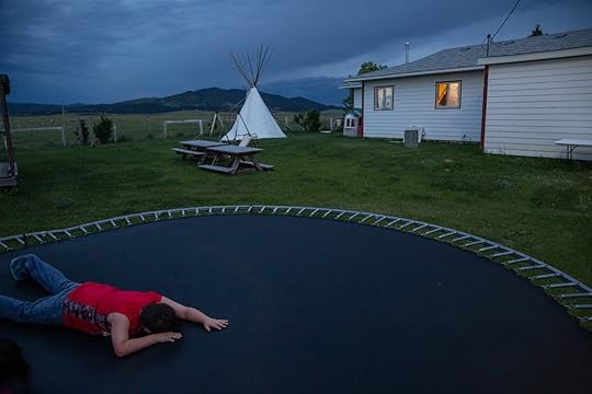 a person lying face down on a trampoline at dusk