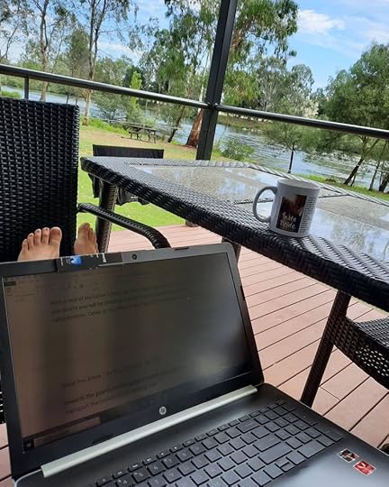 image of laptop and outdoors by a river drinking a cuppa tea.