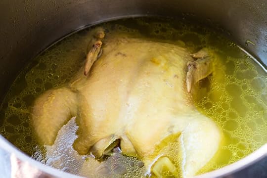 whole chicken simmering for ginger turmeric chicken soup