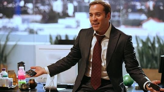 A person in a suit holding a phoneDescription automatically generated with low confidence