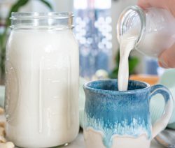 Mason Jar filled with Cashew Milk and a mug being filled