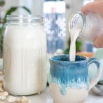 Mason Jar filled with Cashew Milk and a mug being filled