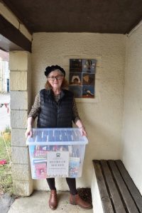 Debbie with box in bus shelter