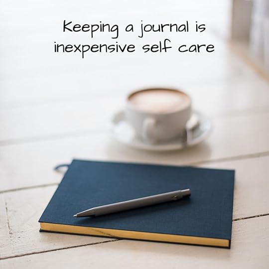 Close journal, pen, and coffee cup on a table.