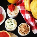 three ramekins of flavored cream cheese on bagel buffet