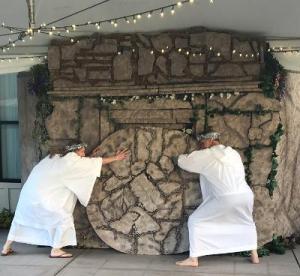 Two angels roll the stone away from Jesus' tomb.