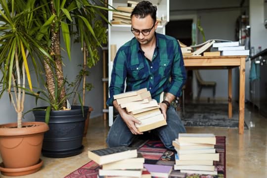 man decluttering books