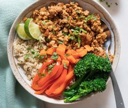 Bowl of spicy tempeh with some brown rice and steamed veggies