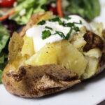 baked potato topped with sour cream and chives
