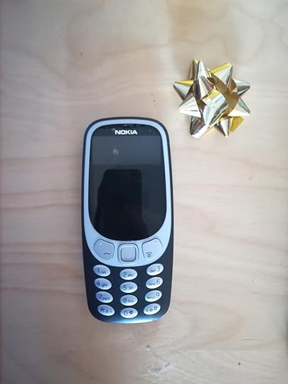 Nokia Brick phone next to a gold foil bow
