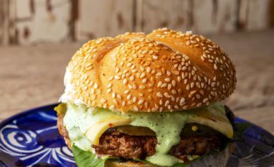 A chorizo burger on a plate, ready to eat.