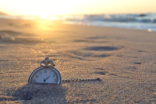 Old-fashioned watch buried in sand at the beach