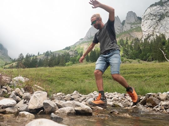 Hiker jumping over river