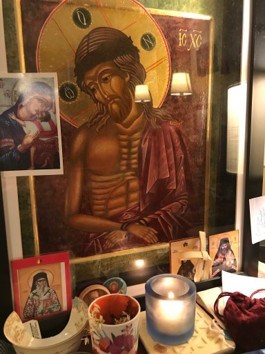 Image of author’s desk with icon of Christ the Bridegroom, wearing a deep purple robe, crowned with thorns, hands bound, with a large gilded halo