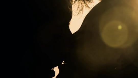 Foto da silhueta de duas pessoas, com um zoom bem próximo das bocas delas se tocando. No canto superior direito tem uma leve luz que parece vir do sol.