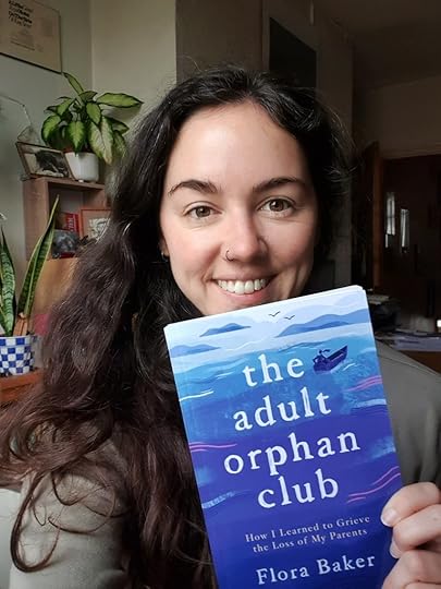 Flora holding The Adult Orphan Club book in paperback