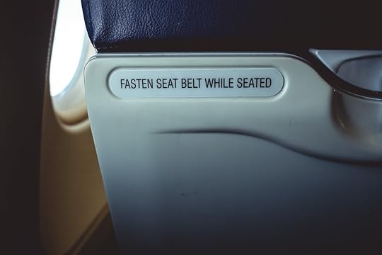 'Fasten seatbelt while seated' sign on a plane