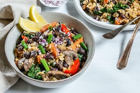 Bowl of veggie filled rice pilaf with two wedges of lemon in the side