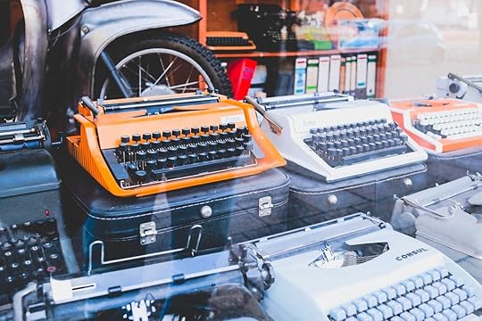 a shop window of typewriters, one is orange