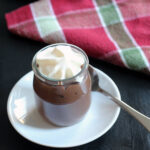 pot of chocolate pudding on plate with spoon
