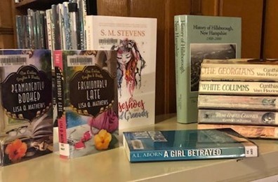 books stacked on table fuller library hillsborough nh