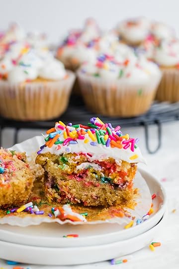Small Cake Stand With Colorful Sprinkled topped and halved Funfetti Cupcake, other similar cupcakes in the background