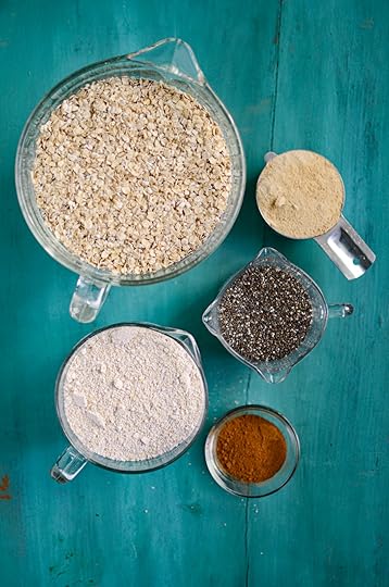 Measured ingredients for homemade instant oats in five different containers, on a blue background.