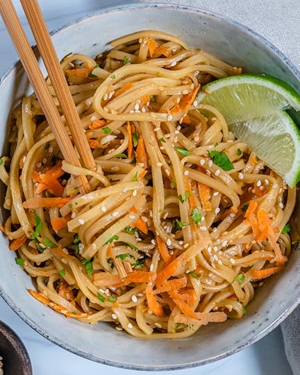 Bowl of Sesame Salad with Two Wedges of Lemon on a Grey Surface
