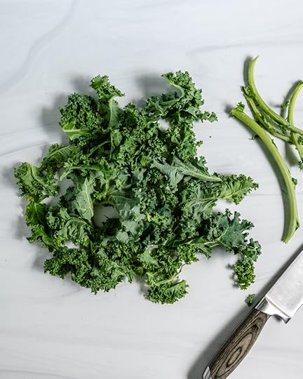 Curly Kale Removing Stem on a Marble Surface