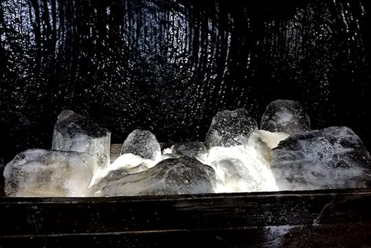 salt blocks in a wooden cart against a black wall made of salt from the turda saltmines in romania